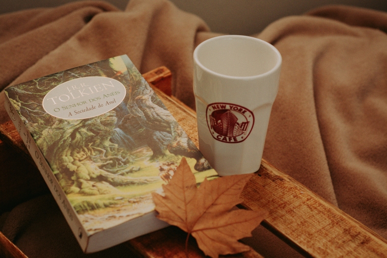 livro do Senhor dos Anéis e um copo do New York Café com uma folhinha de árvore